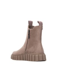 Stivaletto beige in suede, con cerniera laterale e suola in gomma spessa e scanalata. Anello sul retro per una facile indossatura.