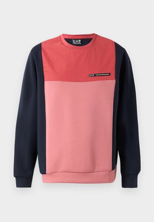 Sudadera color bloqueada en rojo y rosa con mangas largas en navy y cuello redondeado. Presenta una etiqueta de logo en el pecho y puños y dobladillo de canalé.