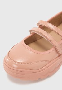 Scarpe sintetiche rosa con punta arrotondata, dotate di due cinturini sulla parte anteriore, texture liscia e suola spessa e testurizzata.
