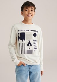 Bílá košile s dlouhým rukávem s nápisem "BLUE RIDGE EXPLORER" v námořnické modři. Obsahuje různé texturované vzory v námořnické modři, včetně hor, vln a teepee.