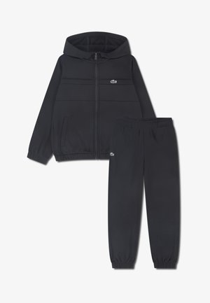 Ensemble veste de survêtement noire et pantalon, en tissu lisse, avec fermeture éclair à l'avant, capuche, poignets élastiques et petit logo sur chaque pièce.