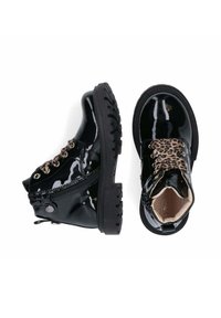 Stivali neri in pelle verniciata con suola in gomma, lacci con stampa leopardata e cerniere laterali, presentano un design massiccio e una suola testurizzata.