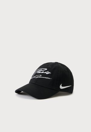 Μαύρο καπέλο Nike με λευκό κεντημένο κείμενο "Paris" και υπογραφή μπροστά, λευκό λογότυπο Nike swoosh στο πλάι, εμφανίζεται σε απλό φόντο.