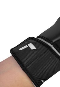 Supporto per polso nero con superficie texturizzata, bordi rinforzati e un accento bianco del logo. Progettato per stabilità e comfort.