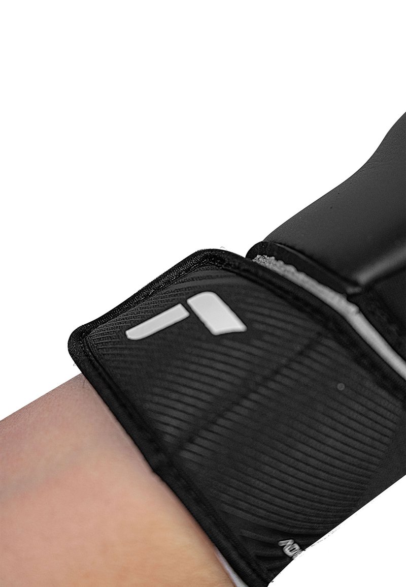 Supporto per polso nero con superficie texturizzata, bordi rinforzati e un accento bianco del logo. Progettato per stabilità e comfort.