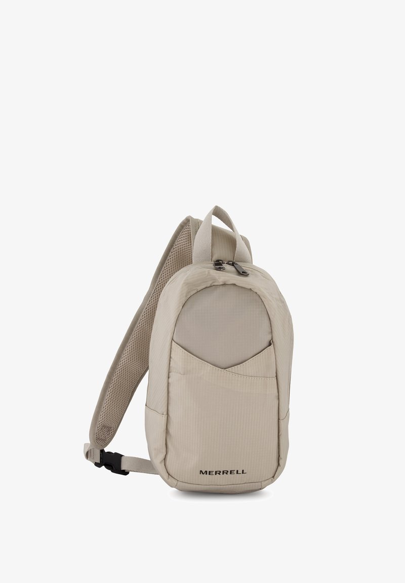 Sac à dos beige en tissu texturé, doté d'une poche avant, d'une sangle d'épaule en mesh rembourrée et d'un logo sur le bas à l'avant.