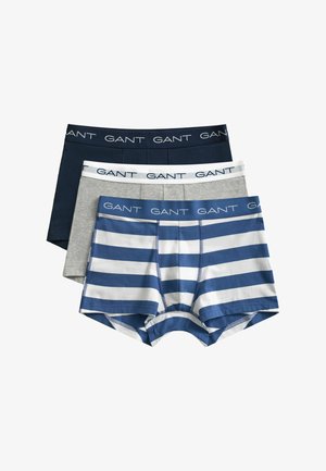 Trois boxers pour hommes pliés empilés, couleurs marine, gris et rayures bleu-blanc, tous avec des tailles élastiques de marque GANT.