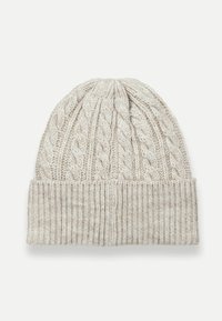 Kötött téli sapka világos bézs színben, fonott mintával a tetején és bordás mandzsettával. Puha struktúrájú fonalból készült, amely meleget és kényelmet biztosít.