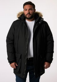 Svart parkas med fuskpälsfoder på huvan, som har en frontdragkedja, sidofickor och ribbade cuffs. Tyget verkar vara strukturerat och isolerande.