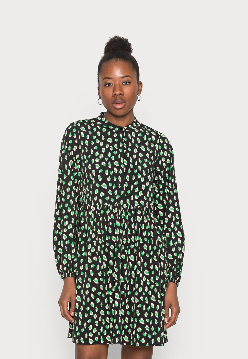 Vestido preto com estampa animal em verde e creme, mangas compridas, frente abotoada, costura na cintura e um corte descontraído, feito de um tecido leve.