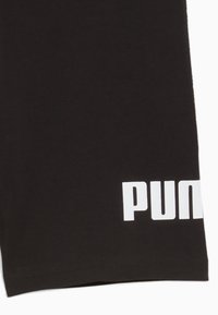 Juodi medvilniniai šortai su tiesiu dizainu, kairėje kojoje didelis baltas „PUMA“ logotipas. Paprastas apvadas ir minkšta tekstūra.