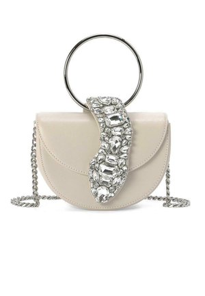 Bolso de mano redondo de piel color crema con una correa de cadena plateada, que presenta un gran adorno de cristal y un asa metálica circular.