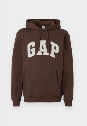 Bruine hoodie met het "GAP"-logo in het wit, voorzien van een voorzak, een capuchon met trekkoord en geribbelde manchetten en zoom. Zachte stofstructuur.
