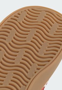 Guma podrážky v svetlých hnedých odtieňoch so zvlneným vzorom a hexagonálnou textúrou, navrhnutá pre trakciu a odolnosť.