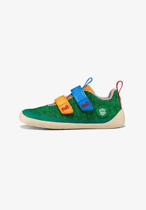 Green fabric shoe with blue, orange, and yellow Velcro straps. Features a rounded toe, beige sole, and a green logo accent on the side.