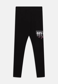 Leggings negros hechos de material suave, con un diseño de texto gráfico en blanco y rosa que dice "CREE en ti." Ajuste elástico con una textura lisa.