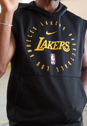 Person iført sort ærmeløs hoodie med gul tekst "Los Angeles Lakers Basketball", Nike swoosh og NBA-logo på fronten.
