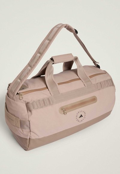 Τσάντα duffle με μαλακό ροζ εξωτερικό, ανθεκτικό ύφασμα, διπλές λαβές, ρυθμιζόμενο λουράκι και τσέπη με φερμουάρ στο μπροστινό μέρος.