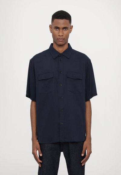 Navy short-sleeve shirt in lightweight fabric, featuring a button-up front, two chest pockets, and a classic collar with a relaxed fit.