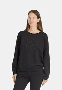 Schwarzer Pullover aus weichem Stoff mit rundem Ausschnitt und Bündchen, versehen mit einem strukturierten Design aus erhabenen Elementen auf der Vorderseite.