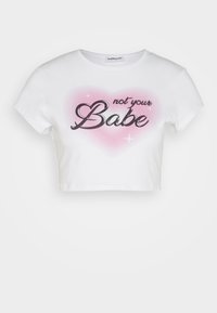Vit kortärmad t-shirt i bomull med en bakgrund av rosa hjärtan och svart text som säger "inte din Babe." Rund halsringning.
