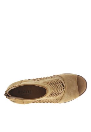 Tandede åbne spidssko til kvinder i ruskind med flettet sidelignende design og lav hæl, mærket "MUSTANG True Denim" indvendigt.