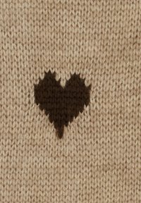 Strikket tekstil i beige med et mørkebrun hjerte-mønster. Teksturen er blød, hvilket fremhæver klare sting og et solidt designelement.