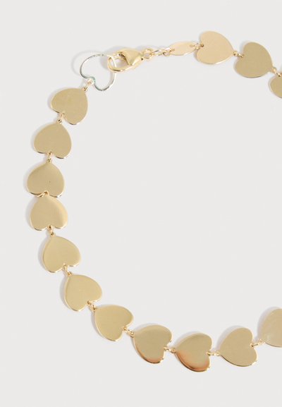 Βραχιόλι από χρυσή αλυσίδα με καρδιές συνδεδεμένες σε σχήμα καρδιάς και κλειδαριά αστακού σε ανοιχτό φόντο.