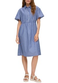 Blau-weiß gestreiftes Kleid mit Kragen, kurzen Ärmeln und elastischem Bund; knielang. Getragen mit beigen Plateausandalen.