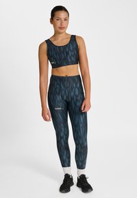 Zestaw sportowy z biustonoszem i legginsami w niebiesko-czarny wzór teksturowany, wykonany z elastycznego materiału o gładkim wykończeniu i z akcentami z logo.