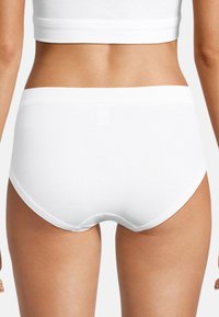 Sous-vêtements en coton blanc avec une texture lisse. Présente un design sans coutures et une coupe à couverture moyenne, avec une ceinture élastique douce.