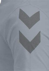 Jasnoniebieska bawełniana koszulka z ciemnoszarymi grafikami w formie jodełki na rękawie. Miękka w dotyku, o standardowym kroju i okrągłym dekolcie.