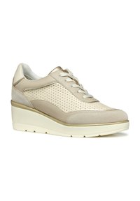 Baskets beiges avec fermeture à lacets, design perforé, accents en suède et talon compensé. Surface texturée et détails métalliques subtils.