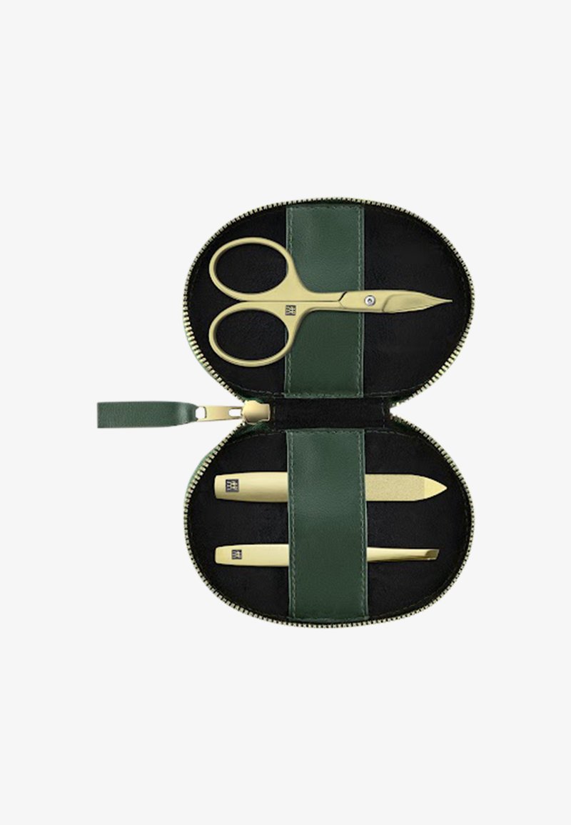 Piccola custodia verde con cerniera che contiene forbicine da manicure dorate, lima per unghie e pinzette con fascette elastiche che fissano ogni strumento.