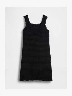 Fekete ujjatlan ruha texturált waffle kötésű anyagból, csipkés élekkel a pántokon, nyakkivágáson és szegélen, fehér háttéren elterítve.