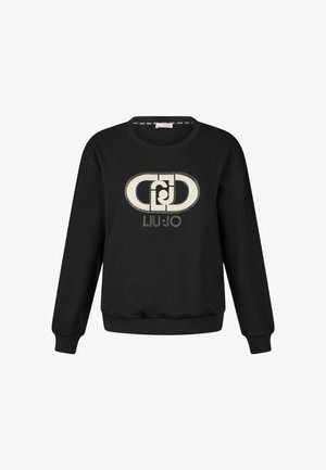 Mustmust, mille soonteutsid ja äärtega, millel on ees suur hõbedane teekristallidega logo kujundus. Pehme kangas, mugav istuvus.
