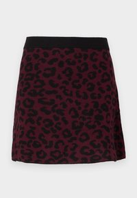 Falda mini color marrón oscuro con estampado de leopardo negro y cinturilla elástica negra sólida sobre un fondo neutro.