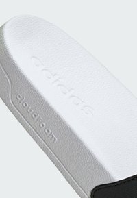 White cloudfoam insole with textured surface and embossed branding. Features a black accent along the edge. Rounded profile.