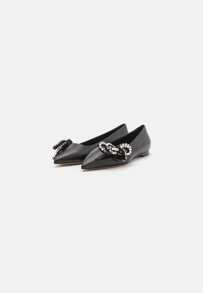 Bailarinas de cuero negro con diseño de punta, que cuentan con un lazo decorativo con acentos de rhinestone en cada zapato. Textura suave y tacón bajo.