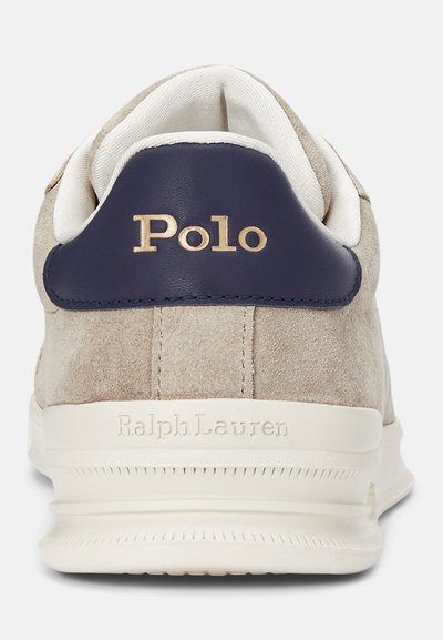 Men’s beige suede sneaker with a navy leather heel, gold "Polo" logo, and white accents. Features a textured sole and padded collar.