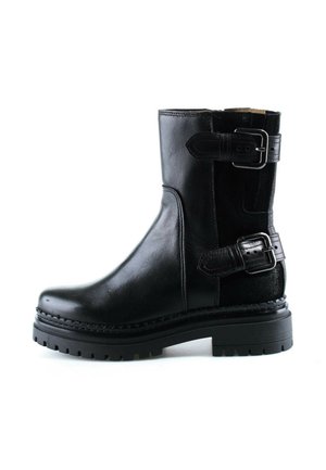 Bota negra de cuero hasta media pantorrilla con suela gruesa y dos correas ajustables con hebilla en el lateral para cierre y decoración.