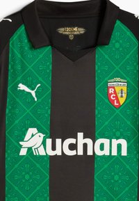 Fekete és zöld sportmez, struktúrált mintával, V-nyakkal, Puma logóval és fehér "Auchan" felirattal. Tartalmazza a Racing Club de Lens emblémáját.
