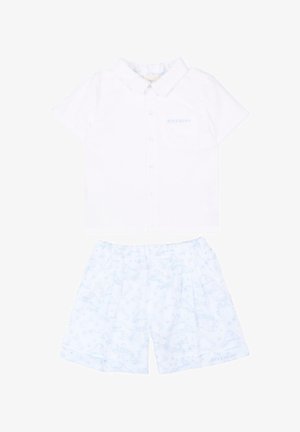 Camicia bianca a maniche corte con bottoni e colletto e pantaloncini azzurri chiari con fantasia, entrambi con un discreto marchio Givenchy.