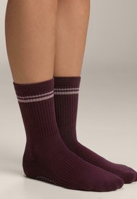 Bordeaux ponožky s rebrovanou textúrou, s dvoma svetlosivými pruhmi okolo vrchu. Dizajn obsahuje polstrovanú podrážku a výšku po členok.