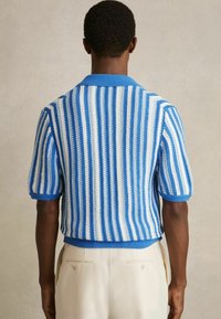 Kurzarm-Polo-Strickpullover im blau-weißen Streifenmuster, mit einem gerippten Kragen und Bündchen, aus einem leichten, strukturierten Gewebe.
