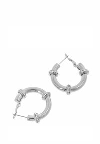 Srebrne kolczyki koła o gładkim, zaokrąglonym kształcie, zdobione małymi, przejrzystymi kamieniami na obręczy. Lekka konstrukcja metalowa.