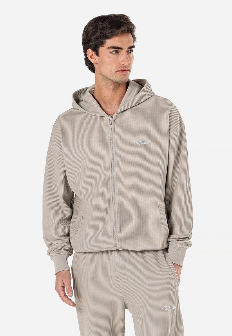 Sweatshirt com capuz em beje com textura canelada, fecho éclair, bolsos frontais e logótipo branco. Textura suave, ajuste descontraído, combinado com calças de moletão a condizer.