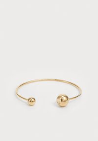 Guldmetallarmband med två sfäriska accenter i vardera änden, slät textur, minimalistisk design och öppen form.