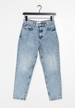 Hellblaue High-Waist-Denim-Jeans mit vorderen Taschen und Knopfverschluss, aufgehängt an einem schwarzen Bügel vor weißem Hintergrund.