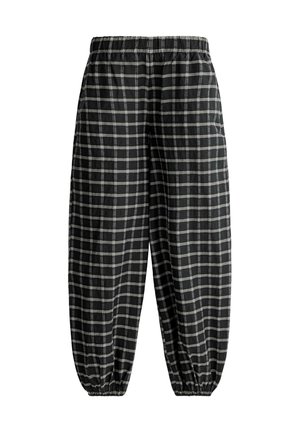 Schwarze locker sitzende Hose mit weißem Karomuster, elastischem Bund und elastischen Bündchen an den Fußgelenken.